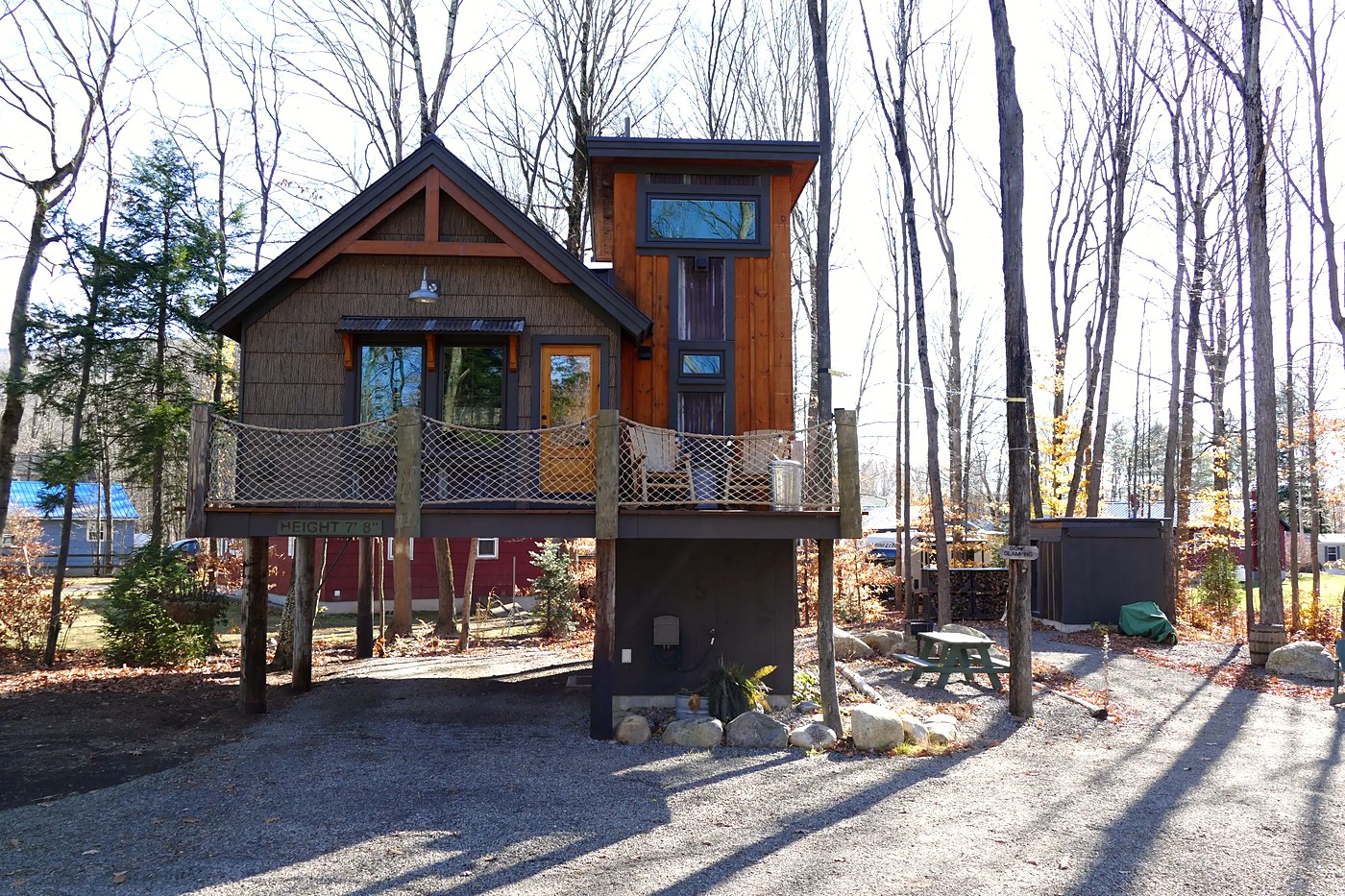 The Majestic Timber Cottage exterior — a treehouse on stilts among the trees