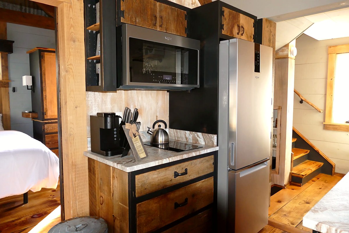 Fully equipped kitchen with marble countertops, full-size fridge, and custom cabinetry