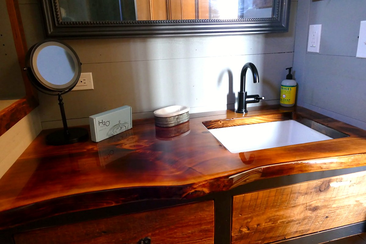 Bathroom vanity with stunning live-edge wood countertop and matte black fixtures